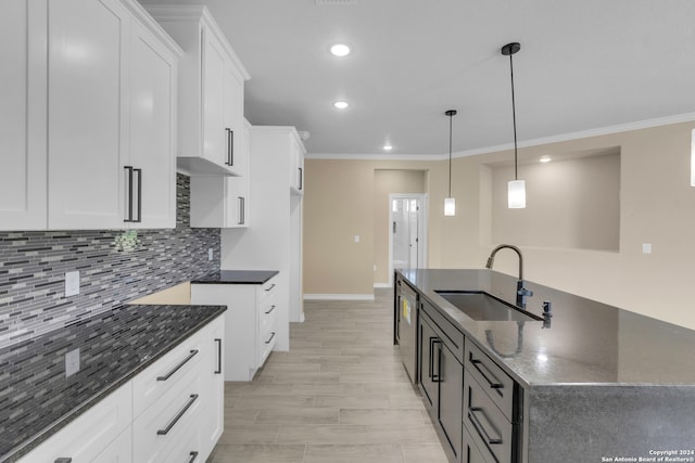 kitchen with white cabinetry, decorative light fixtures, sink, stainless steel dishwasher, and light hardwood / wood-style floors