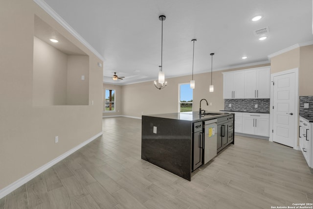 kitchen with ceiling fan with notable chandelier, a kitchen island with sink, plenty of natural light, and sink