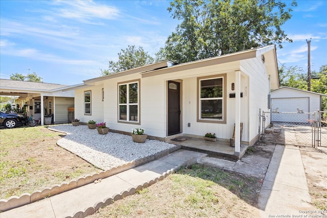 single story home featuring covered porch, an outbuilding, and a garage