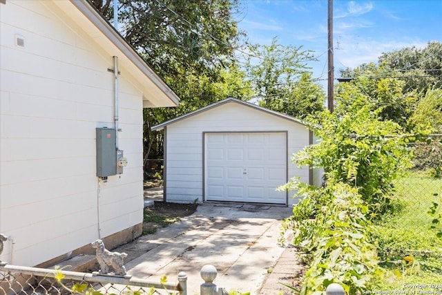 detached garage with driveway and fence