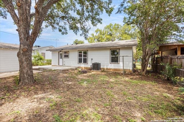 back of property with central AC unit and a patio