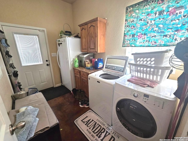 laundry room featuring washing machine and clothes dryer and cabinets