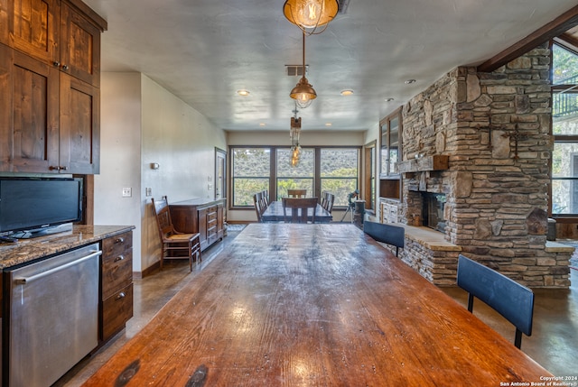 unfurnished living room featuring a healthy amount of sunlight and a stone fireplace