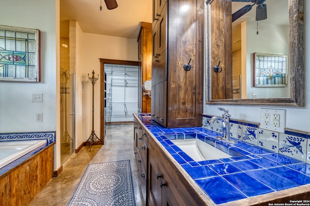 bathroom with vanity, independent shower and bath, concrete flooring, and ceiling fan