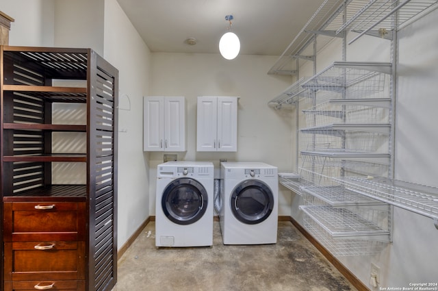 washroom featuring cabinets and separate washer and dryer