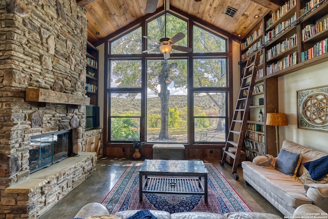 living room featuring wood ceiling, ceiling fan, concrete flooring, a stone fireplace, and high vaulted ceiling