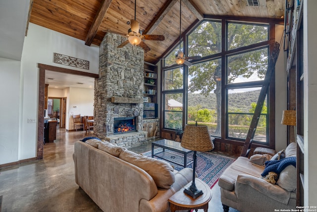 living room featuring high vaulted ceiling, concrete floors, ceiling fan, a stone fireplace, and wooden ceiling