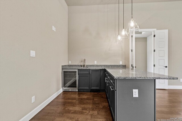 kitchen with dark hardwood / wood-style floors, kitchen peninsula, wine cooler, and decorative light fixtures