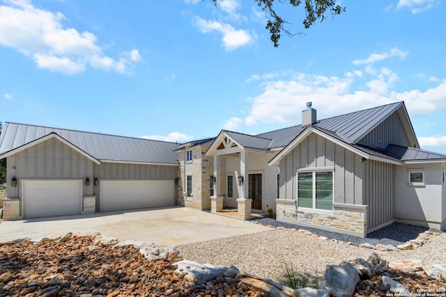 modern farmhouse with a standing seam roof, stone siding, board and batten siding, metal roof, and a chimney