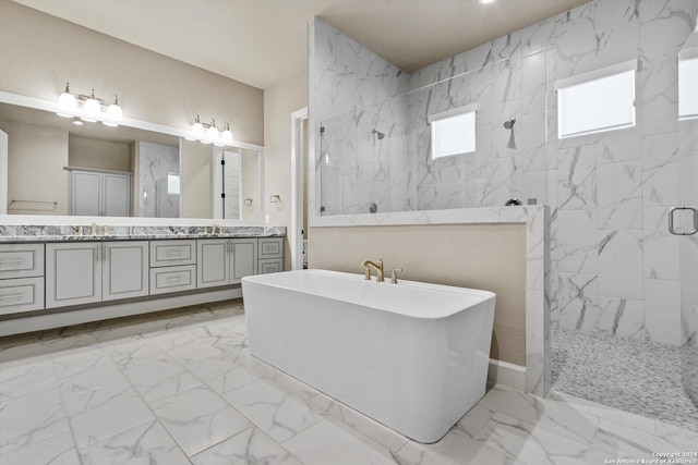 bathroom with a freestanding tub, marble finish floor, a sink, a marble finish shower, and double vanity