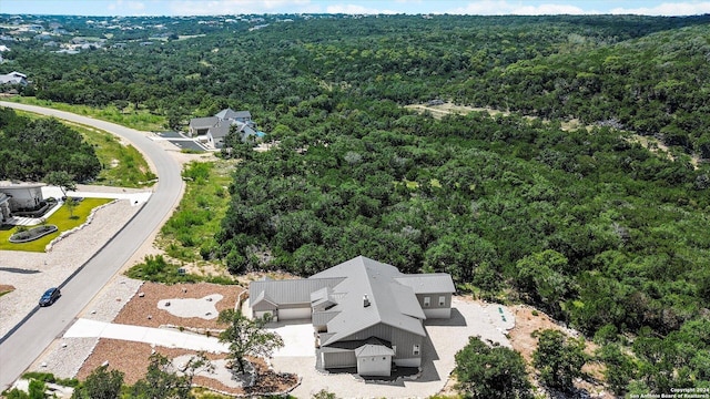 birds eye view of property featuring a view of trees