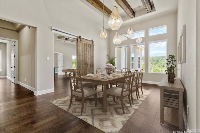 dining area featuring dark wood-style floors, beam ceiling, baseboards, and a barn door