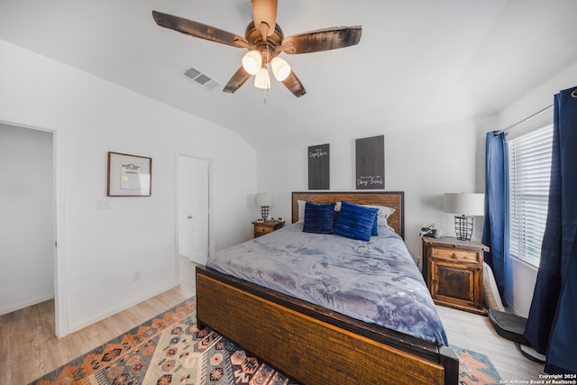 bedroom featuring ceiling fan, light hardwood / wood-style floors, and vaulted ceiling