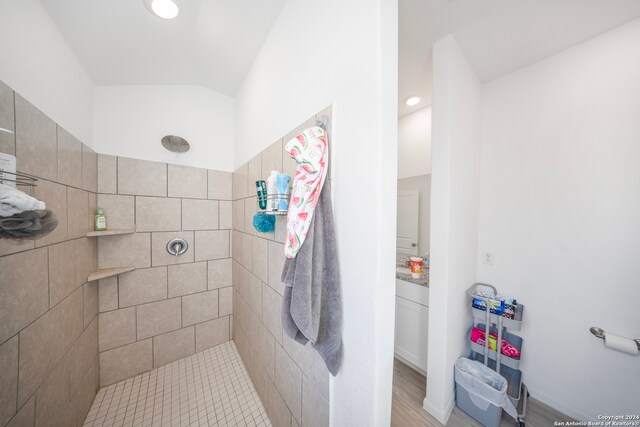 bathroom with a tile shower and vanity