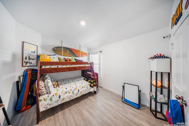 bedroom featuring lofted ceiling and light hardwood / wood-style flooring