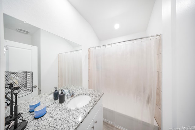 bathroom with vanity, hardwood / wood-style flooring, vaulted ceiling, and plus walk in shower