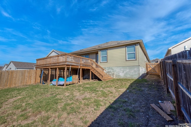 back of house with a deck and a lawn