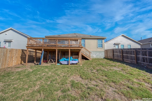 rear view of house featuring a wooden deck and a yard