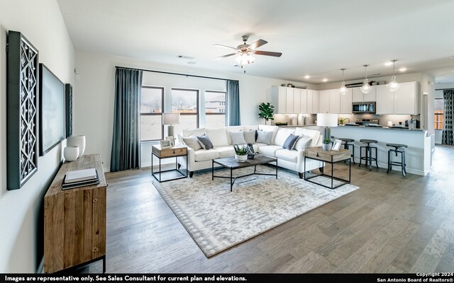 living room with wood-type flooring and ceiling fan