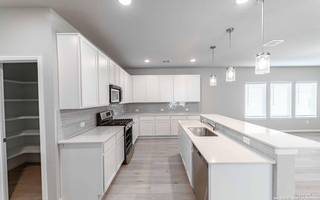 14735 Sycamore Xing, San Antonio, TX 78252 - kitchen featuring light wood finished floors, a kitchen breakfast bar, visible vents, light stone counters, and appliances with stainless steel finishes
