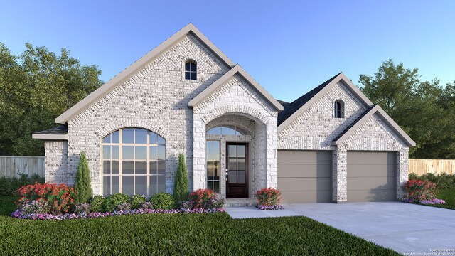 french country home featuring a front yard and a garage