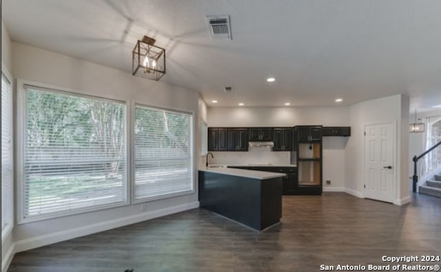 kitchen featuring dark hardwood / wood-style floors, kitchen peninsula, and sink