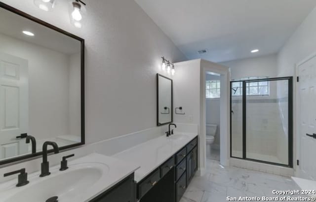 bathroom with a shower with door, vanity, and toilet