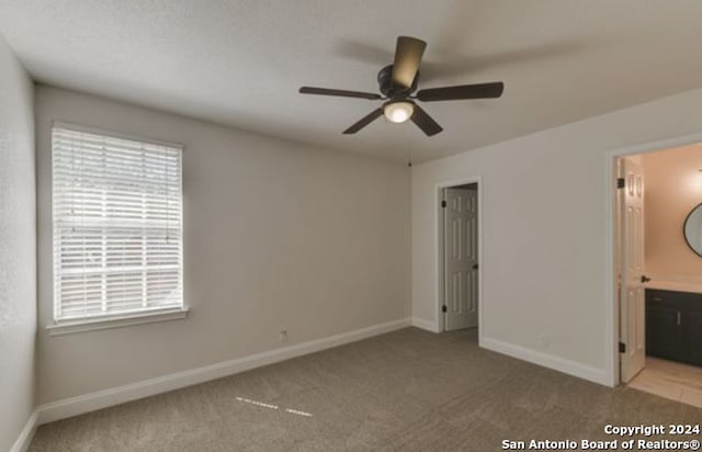 unfurnished bedroom with ensuite bath, ceiling fan, and carpet floors