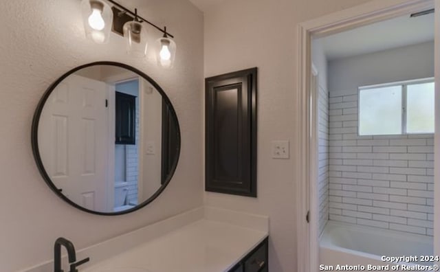 bathroom with tiled shower / bath combo and vanity