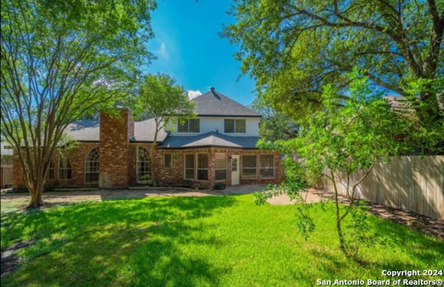 rear view of house with a yard and a patio