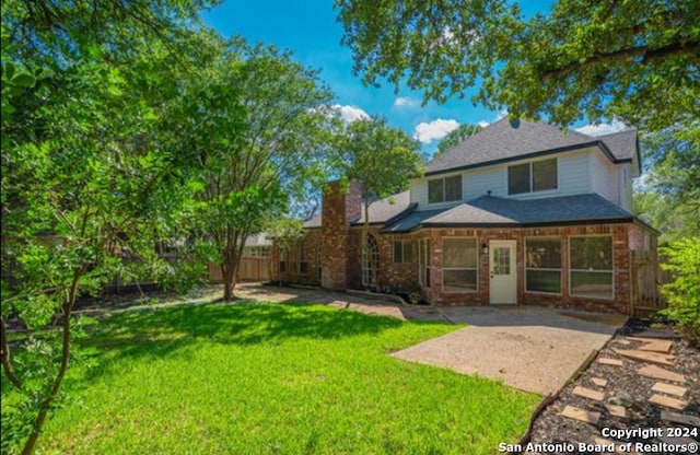 rear view of house with a yard and a patio