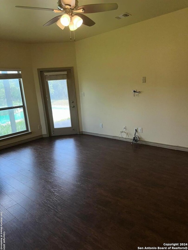 empty room with dark wood-type flooring and ceiling fan