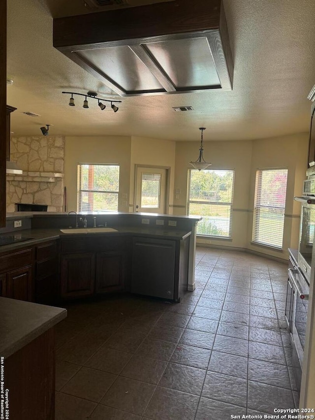 kitchen featuring sink, extractor fan, a textured ceiling, black electric cooktop, and stainless steel oven