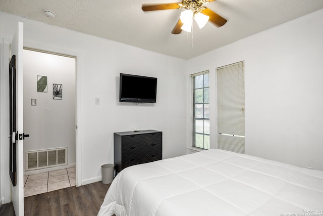 bedroom featuring a textured ceiling, ceiling fan, and dark hardwood / wood-style floors