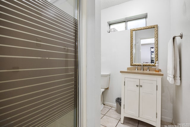 bathroom featuring tile patterned floors, toilet, a textured ceiling, and vanity