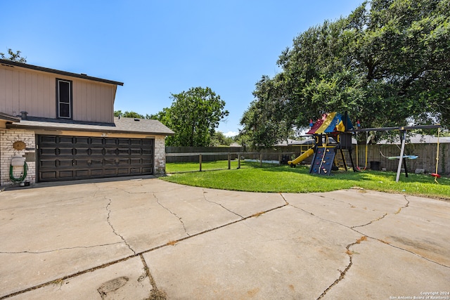 view of patio / terrace with a playground and a garage