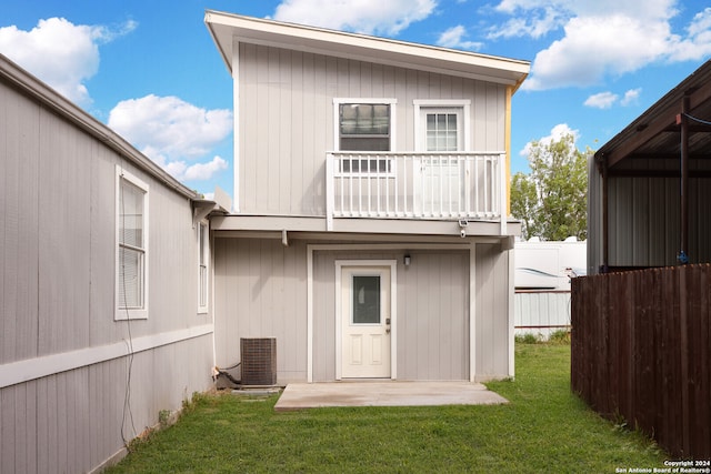 back of house with a lawn, a balcony, a patio, and central AC unit