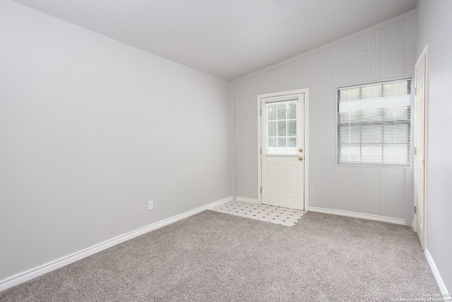 carpeted empty room with vaulted ceiling