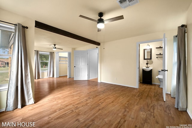 unfurnished living room with ceiling fan, beam ceiling, and hardwood / wood-style flooring