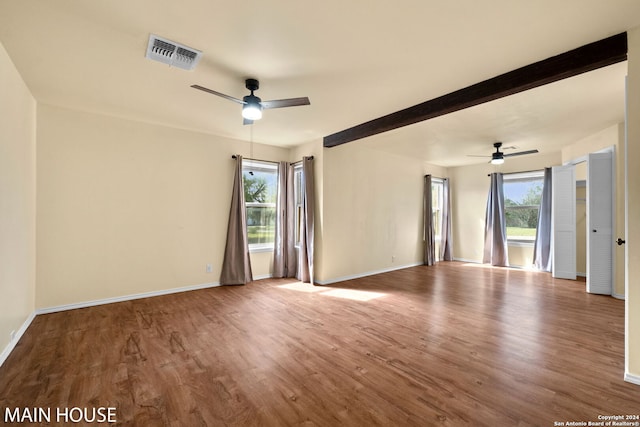 unfurnished room with plenty of natural light, ceiling fan, and dark hardwood / wood-style floors