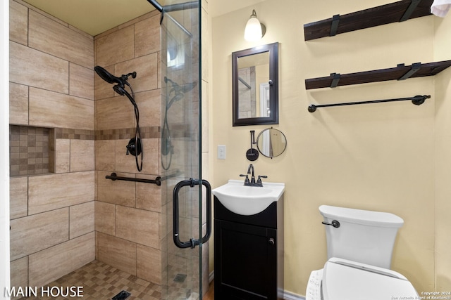 bathroom with an enclosed shower, toilet, and vanity