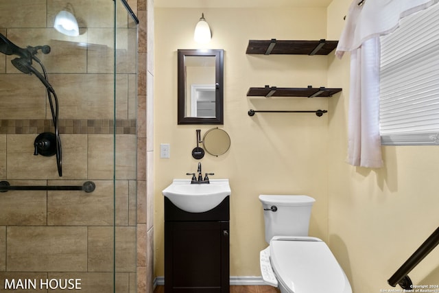 bathroom featuring vanity, toilet, and a shower with door