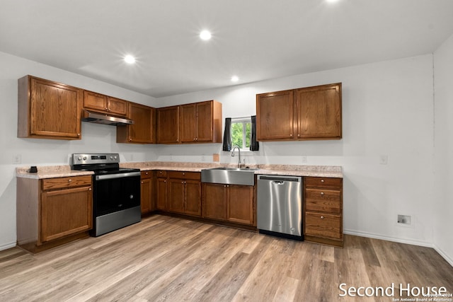 kitchen with stainless steel appliances, light hardwood / wood-style floors, and sink