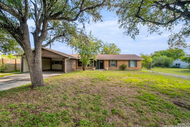 ranch-style home featuring a carport and a front lawn