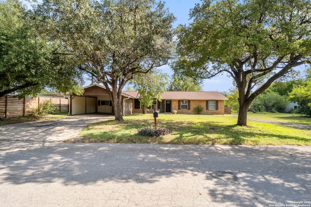 ranch-style home with a carport and a front lawn