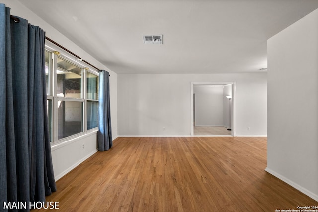 unfurnished room with hardwood / wood-style flooring