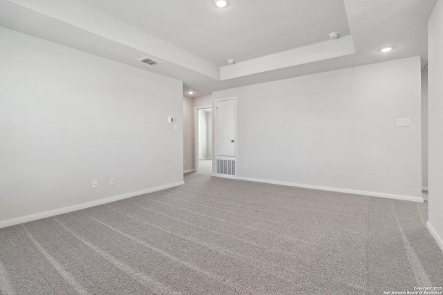 unfurnished room with carpet, a raised ceiling, and baseboards