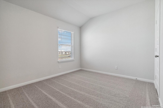 unfurnished room featuring baseboards, vaulted ceiling, and carpet flooring