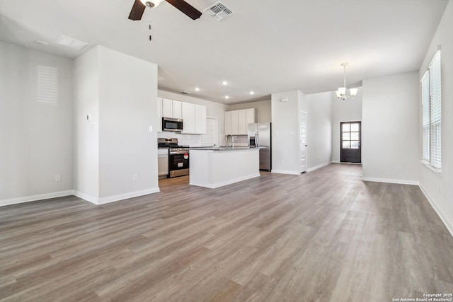 kitchen featuring open floor plan, appliances with stainless steel finishes, light wood-style flooring, and visible vents