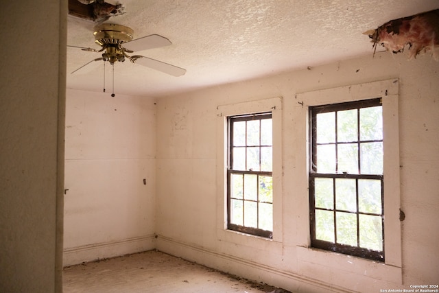 empty room featuring a textured ceiling, plenty of natural light, and ceiling fan